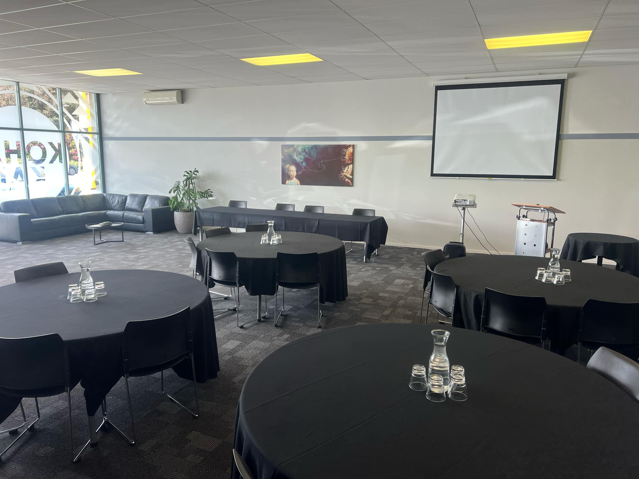 The Huia Room set up cabaret-style with round tables and a projector screen